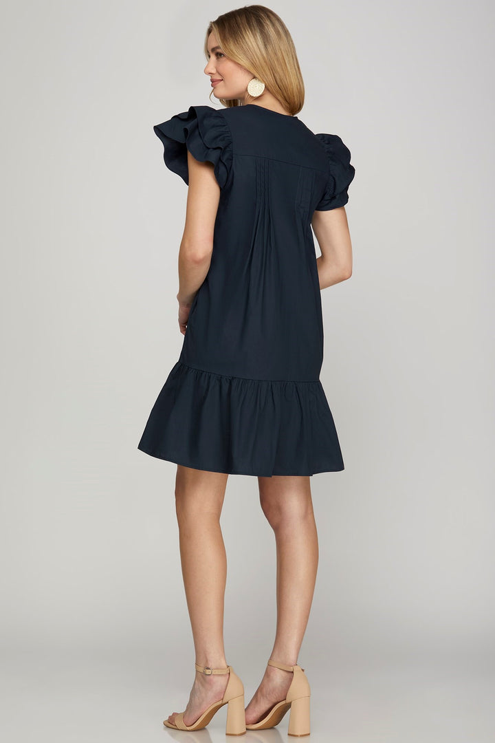 Flutter Sleeve white Embroidered Navy Dress drop ruffle hem pleated detailing on model