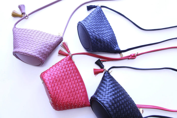 woven triangle purse with a long strap and keychain detail in Tres Chic